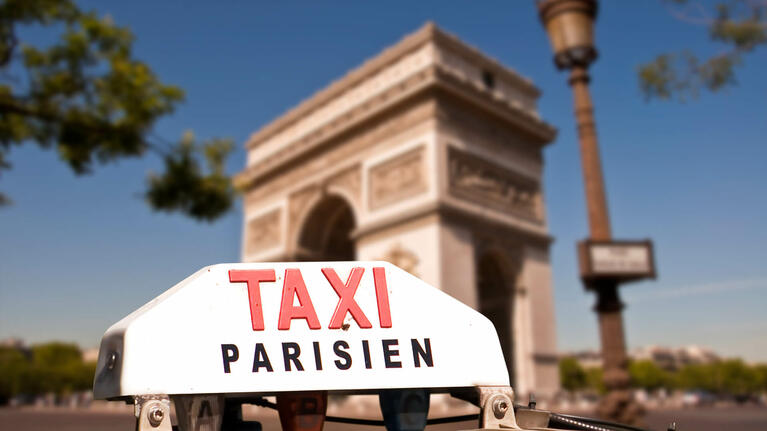 An taxi awaits customers beside the Arc de Triomphe