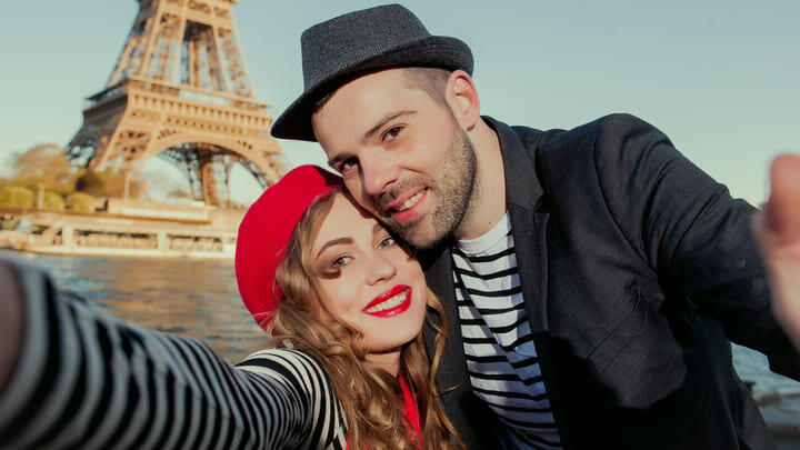 A couple in stripy shirts in front of the Eiffel Tower
