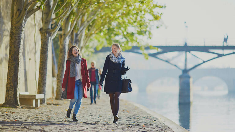 Zwei Frauen spazieren am sonnigen Ufer der Seine