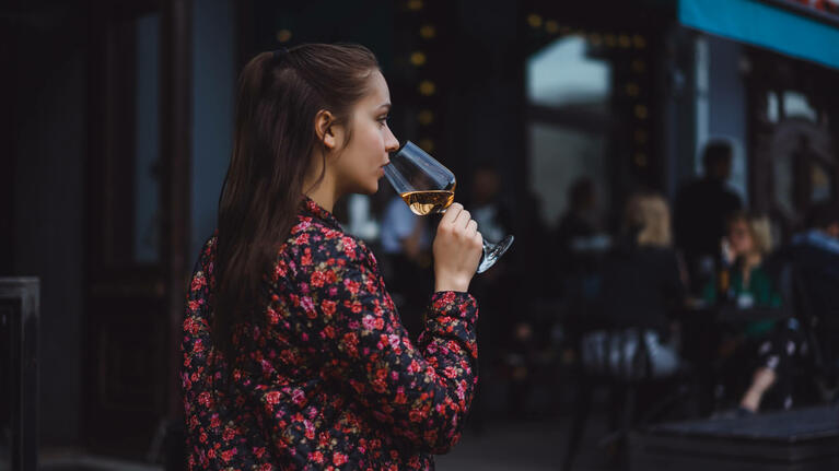 A woman smells a glass of wine