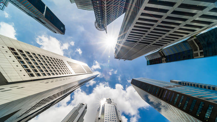 View looking up at skyscrapers in Singapore's CBD on a sunny day.