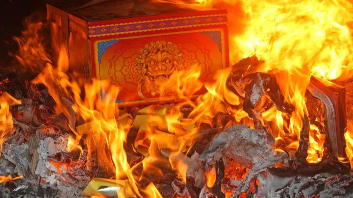 Flames surround a decorated paper box, burned for the Qingming festival Singapore