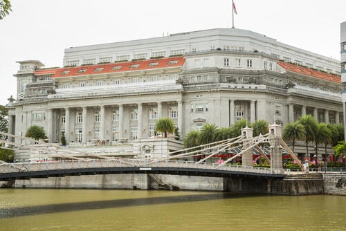Fullerton Hotel with Cavenagh Bridge in the foreground, Singapore