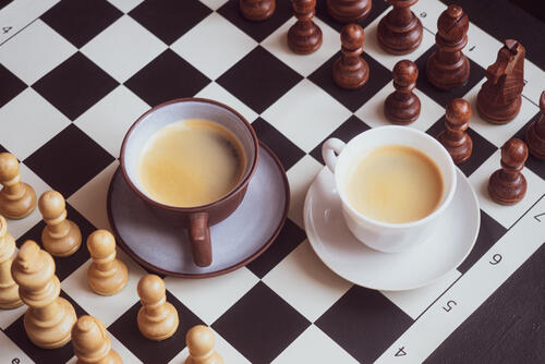 Two cups of coffee on a chess board