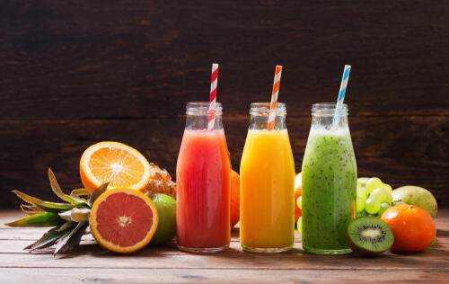Three colorful fruit smoothies with straws