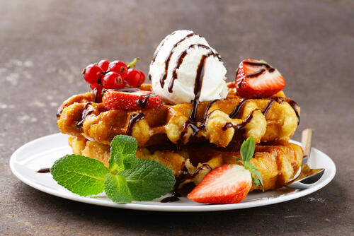 Ice cream on waffles with strawberries and mint