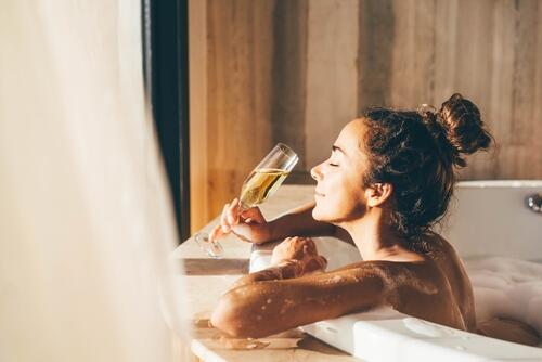 Woman sips champagne in a hot tub
