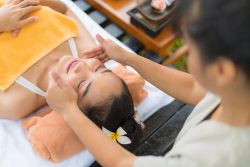 A woman getting a facial treatment at a luxury spa
