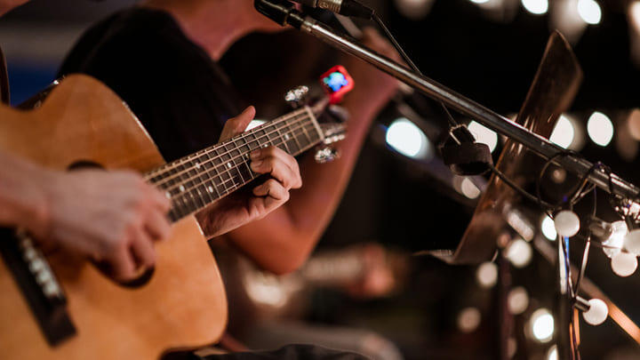 Duo singing and playing acoustic guitar in a bar.