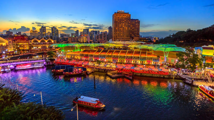 Singapore river cruise against the illuminated city skyline at dusk