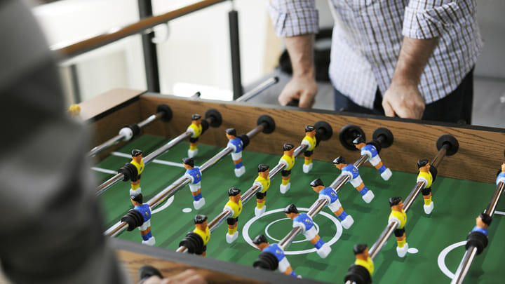 Friends playing at a foosball table
