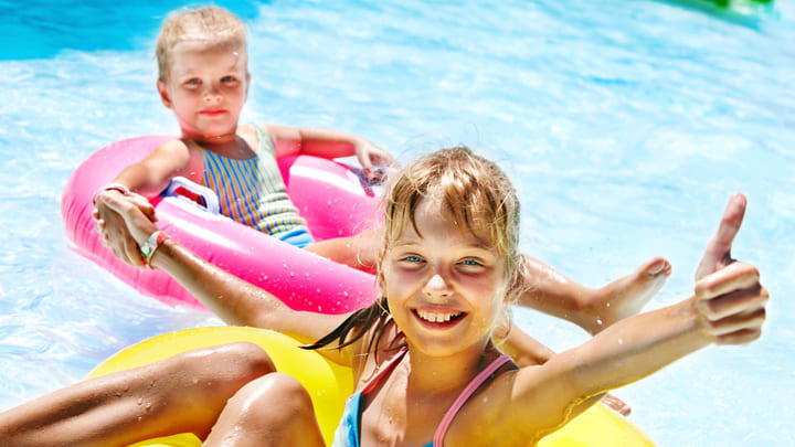 Kids playing on inflatables in a swimming pool