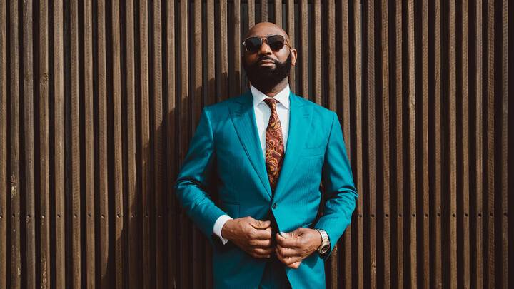 Dapper man in sunglasses and an electric blue suit.