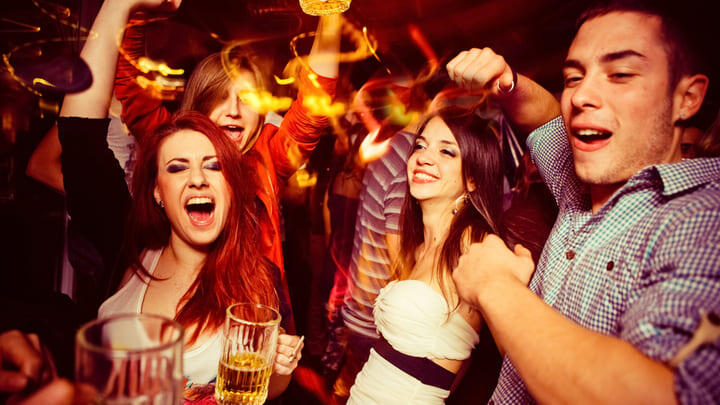 Revelers partying in a busy bar.