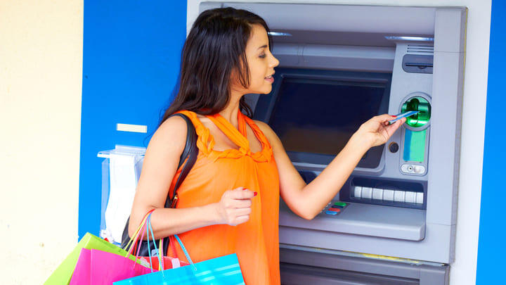 Woman pausing at an ATM during a shopping spree.