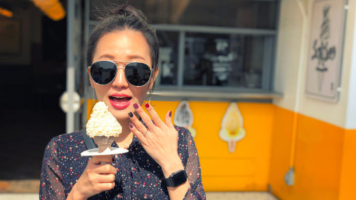 Woman in sunglasses eating ice cream.