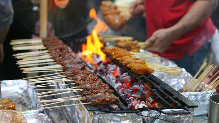 Satay skewers cooking at a Singapore hawker stall