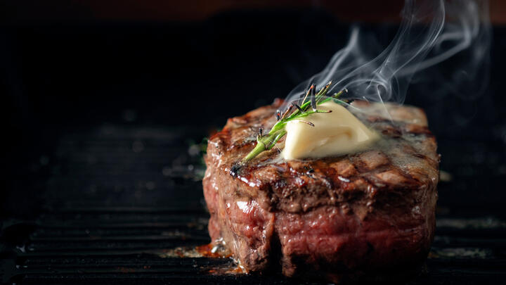 Steak cooking on a grill.