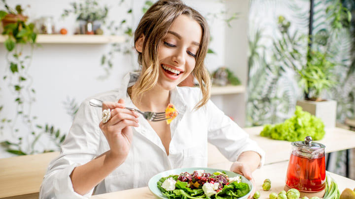 Woman eating a colorful salad.