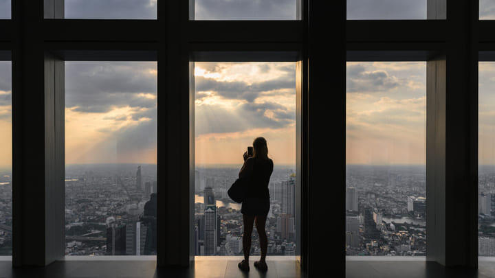 Tourist taking in dusk views from the observation platform at King Power Mahanakhon Skywalk.