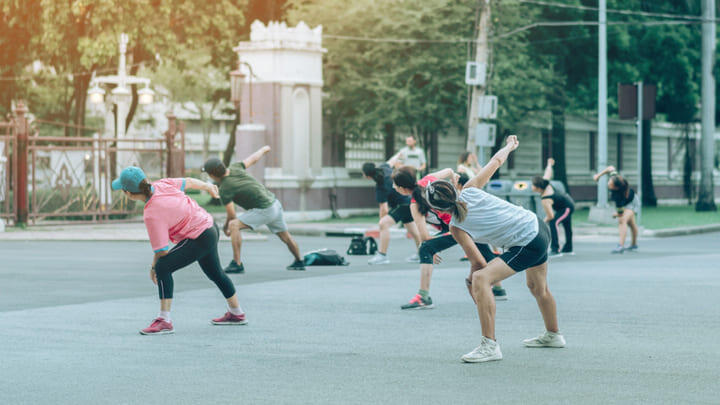 Group of people taking an aerobics class in Lumpini Park, Bangkok.