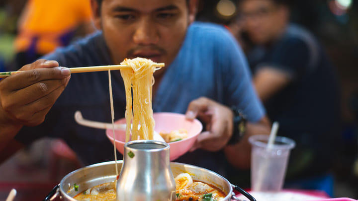 Man eating noodles in Chinatown, Bangkok.