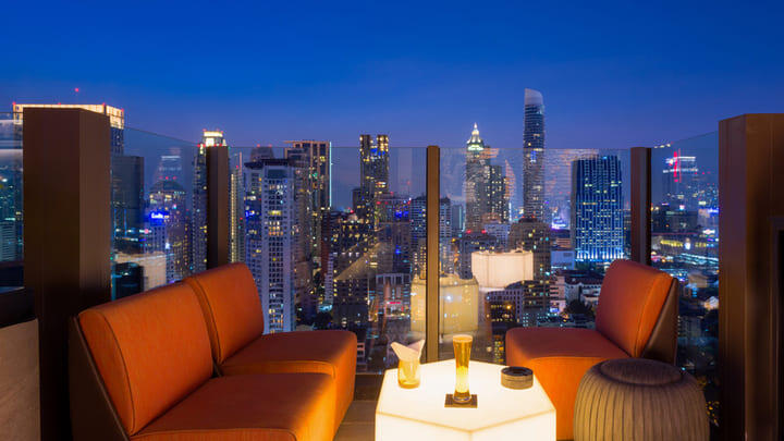 Rooftop bar with nighttime views of the Bangkok skyline.