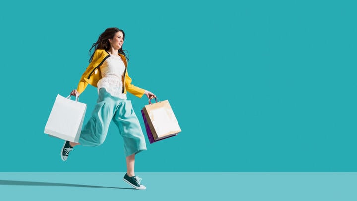 A happy shopper skipping along with bags full of goodies.