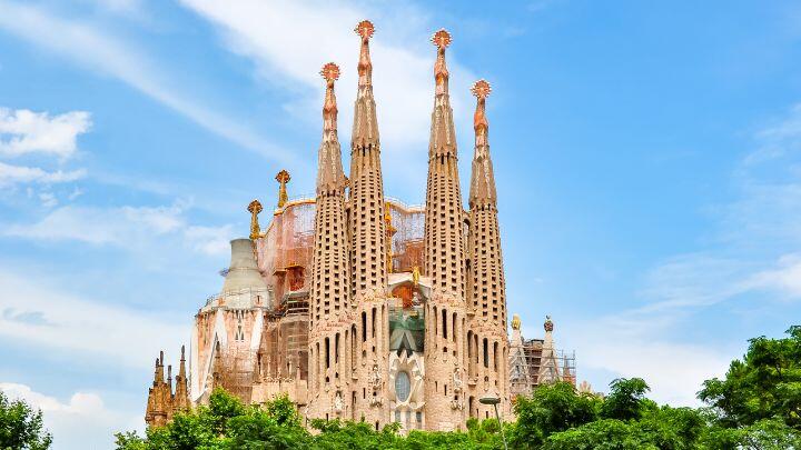 Wide shot of spires of Sagrada Familia, Barcelona against blue sky