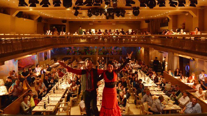 Two performers pose in front of tables of diners at Palacio del Flamenco Barcelona