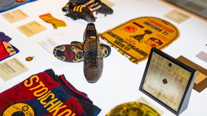 Close up of items of Barcelona football memorabilia in museum display, including shirt and boots