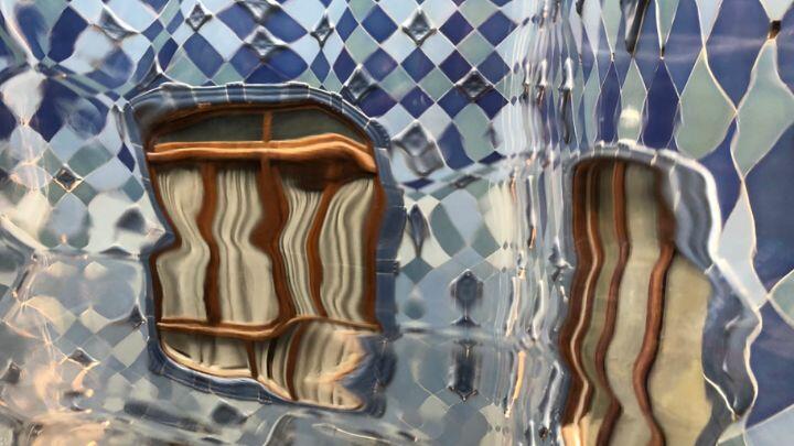 Distorted image shot through glass of windows and blue tiles in Casa Battle, Barcelona
