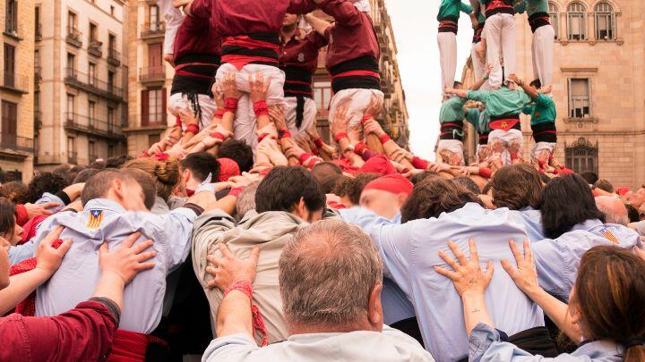 Close up of teams of castellers (human towers) supporting one another in Barcelona streets