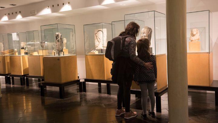 Back view of woman and child studying display cases at the Egyptian museum Barcelona