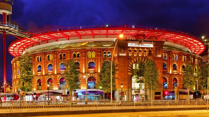 Red floodlit architectural profile of former bullring La Arenas de Barcelona
