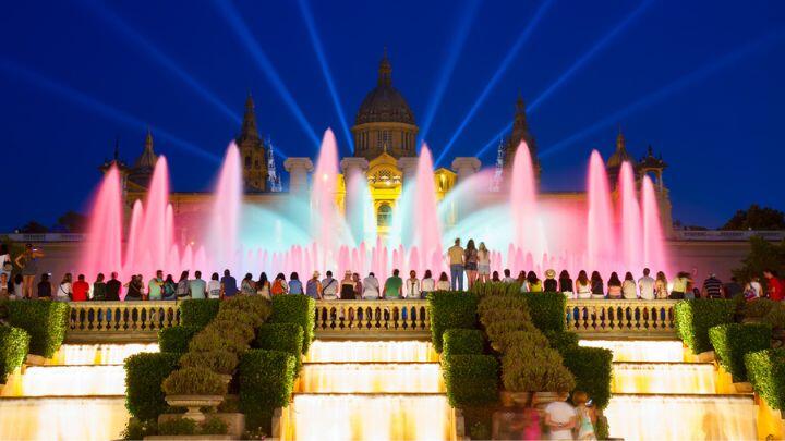 Pink fountains and yellow cascades against dark blue sky, Montjuic Barcelona
