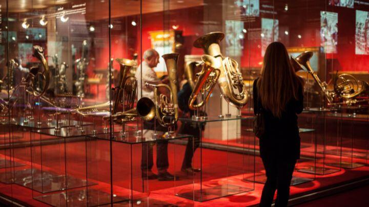 Woman looks at display cabinet of brass instruments at Barcelona music museum