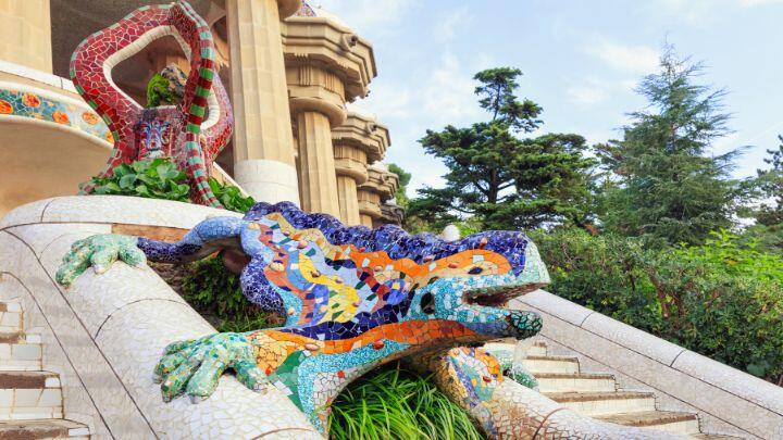 El Drac - brightly coloured mosaic dragon on stone steps in Parc Guell Barcelona