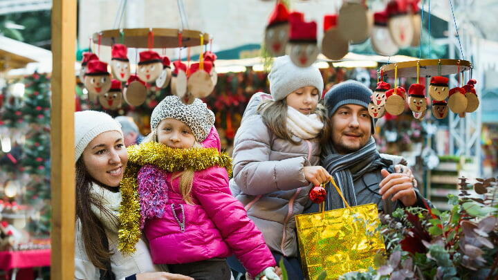 Family browsing gifts at a Christmas market stall