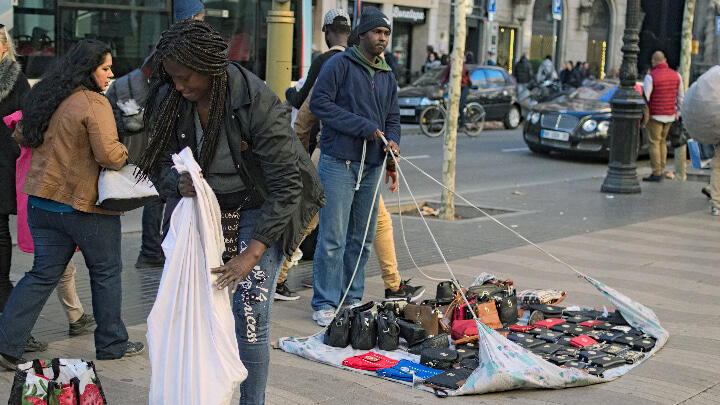 Unlicensed street merchants packing away their goods