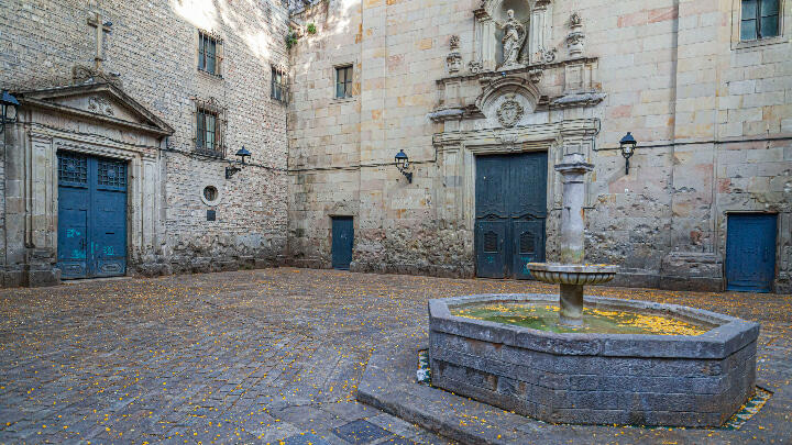 A small fountain in the center of Plaça Sant Felip Neri