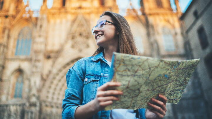 A woman holding a map in front of the Barcelona Cathedral