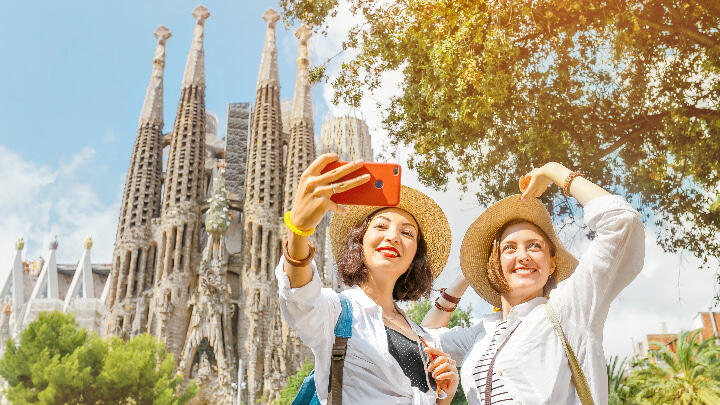 Two women taking a selfie in front of the Sagrada Familia