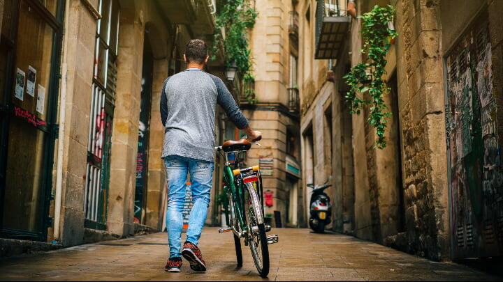 Man walking with a bicycle through Barcelona's Gothic Quarter