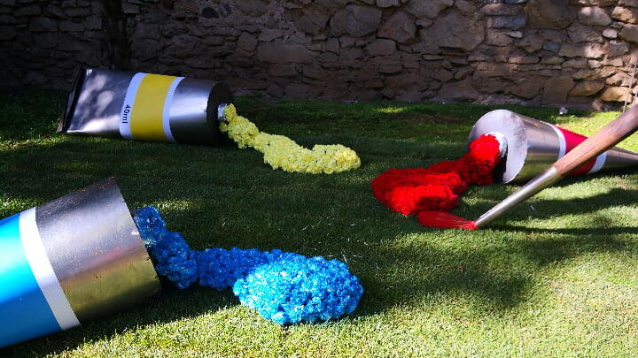 Colorful carnations flowing from giant paint tubes at the Girona Flower Festival