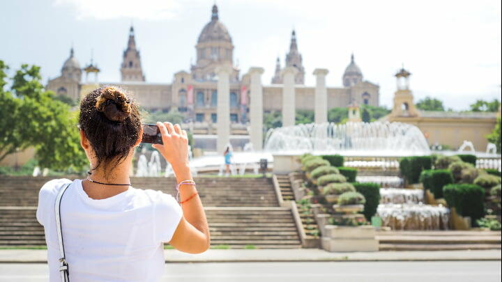 Female tourist taking photos of the Palau Nacional