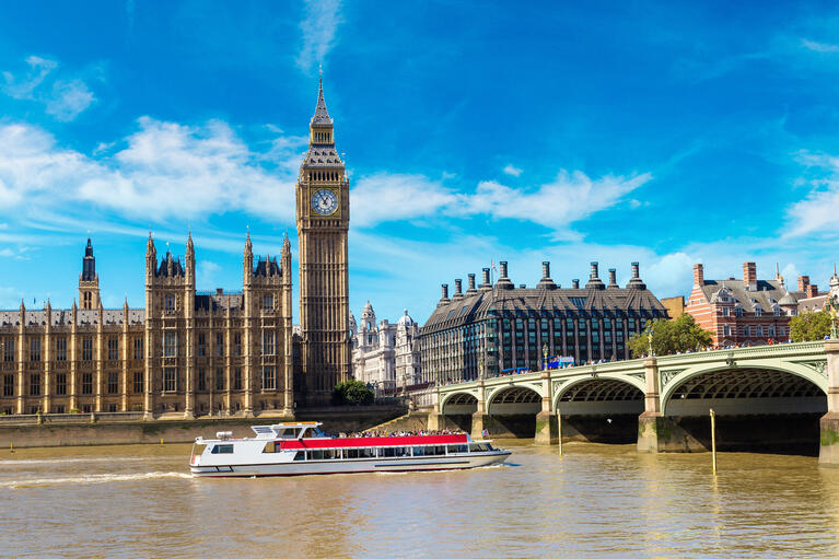 Ein Schiff fährt bei schönem Wetter in London unter der Tower Bridge hindurch.