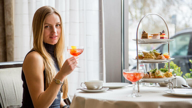 A woman enjoying afternoon tea at a top London hotel