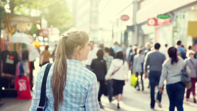 A woman walks alone through a busy London street